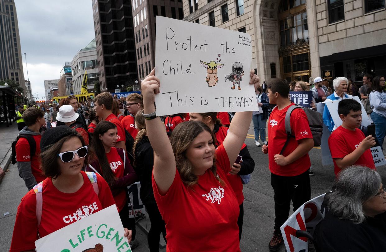 Tiffany Coller of Fort Jennings holds up a homemade sign before the March for Life on High Street.