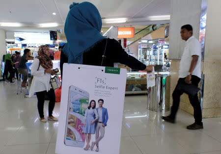 A salesperson promotes OPPO smartphones to customers at ITC Roxymas shopping mall in Jakarta, Indonesia, September 22, 2016. REUTERS/Beawiharta