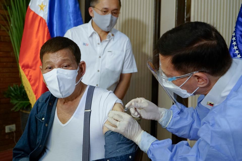 <p>In this photo provided by the Malacanang Presidential Photographers Division, Philippine President Rodrigo Duterte, left, is inoculated with China's Sinopharm Covid-19 vaccine by Health Secretary Fracisco Duque III at the Malacanang presidential palace in Manila, Philippines on3 May, 2021</p> (AP)