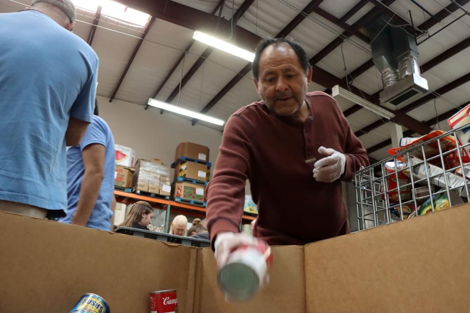 Volunteer Arthur Avila transfers cans of food to the proper bins at the High Plains Food Bank on Oct. 26.