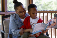 Adriane Burnett reads to her son Karter Robinson on Saturday, April 14, 2024 in Birmingham, Ala. Women's participation in the American workforce has reached a high point, but challenges around child care are holding back many working class parents. When women without college degrees face an interruption in child care arrangements – whether it's at a relative's home, a preschool or a daycare center – they are more likely to have to take unpaid time or to be forced to leave their jobs altogether, according to an Associated Press analysis. (AP Photo/Butch Dill)