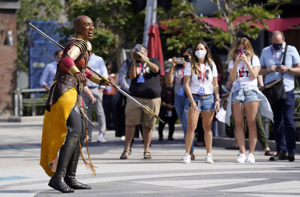 Guests look on as a character from the film "Black Panther" performs during "The Warriors of Wakanda: The Disciplines of the Dora Milaje" show at the Avengers Campus media preview at Disney's California Adventure Park on Wednesday, June 2, 2021, in Anaheim, Calif. (AP Photo/Chris Pizzello)