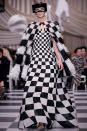 <p>A model wears a black and white checkered feather cape and matching gown from the Dior Haute Couture SS18 collection. (Photo: Getty) </p>