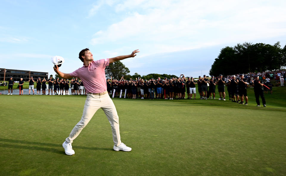 Rasmus Hojgaard throws his cap in the air after winning on the sixth playoff hole