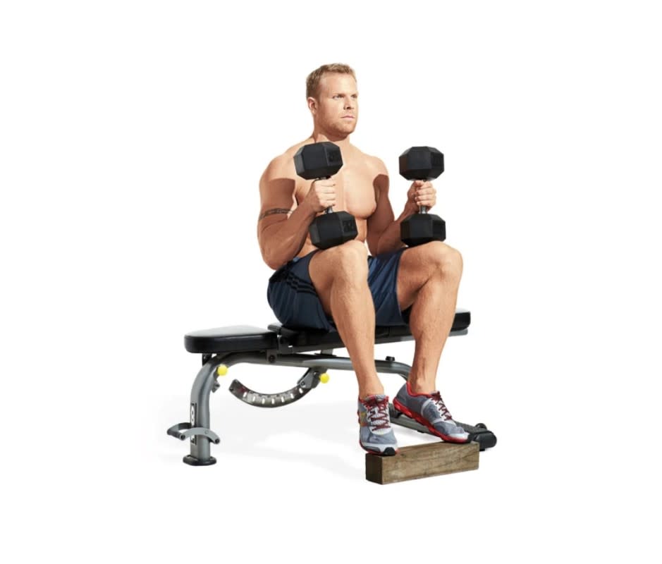 <p>Beth Bischoff</p>How to Do It:<ol><li>Use a seated calf raise machine or sit on a bench and rest the balls of your feet on a block or step (and hold <a href="https://www.yahoo.com/lifestyle/11-best-adjustable-dumbbells-home-010025583.html" data-ylk="slk:dumbbells;elm:context_link;itc:0;sec:content-canvas;outcm:mb_qualified_link;_E:mb_qualified_link;ct:story;" class="link  yahoo-link">dumbbells</a> on your thighs for resistance).</li><li>Your knees should be bent 90 degrees and your toes turned out about 15 degrees.</li><li>Allow your heels to drift toward the floor until you feel a stretch in your calves.</li><li>Now drive the balls of your feet into the platform and raise your heels as high as possible.</li></ol>