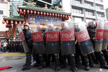 Riot police protect the entrance to Chinatown from "Red Shirt" demonstrators during a rally to celebrate Malaysia Day and to counter a massive protest held over two days last month that called for Prime Minister Najib Razak's resignation over a graft scandal, in Malaysia's capital city of Kuala Lumpur in this September 16, 2015 file photo. REUTERS/Olivia Harris/Files