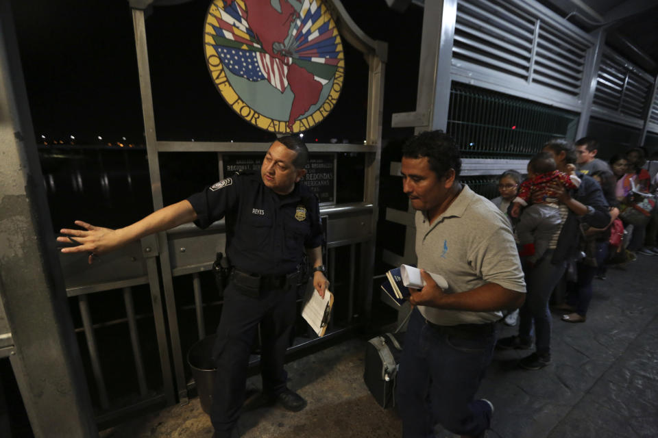 En esta foto del 17 de septiembre de 2019, un agente de la Patrulla Fronteriza señala a dónde ir a una familia migrante nicaragüense que está aplicando para pedir asilo en Estados Unidos. La imagen fue tomada en el Puente Internacional 1 que conecta Nuevo Laredo, México, con Laredo, Texas. El gobierno de Estados Unidos ha impuesto límites para los aplicantes de asilo, lo cual ha transformado a la frontera en un embudo donde cada vez son menos los que pueden entrar legalmente y más los que salen mediante el programa conocido como “Permanecer en México”, una estrategia mediante la que Washington ha devuelto a más de 55.000 personas mientras sus solicitudes de asilo deambulan, con pocas posibilidades de prosperar, por la intrincada burocracia de unas cortes estadounidenses desbordadas. (AP Foto/Fernando Llano)