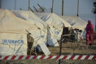 Migrants are seen inside the new temporary refugee camp in Kara Tepe, on the northeastern island of Lesbos, Greece, Saturday, Sept. 19, 2020. Police on the Greek island of Lesbos on Friday resumed relocating migrants rendered homeless when fires ravaged the country's largest refugee camp amid a local COVID-19 outbreak. (AP Photo/Panagiotis Balaskas)