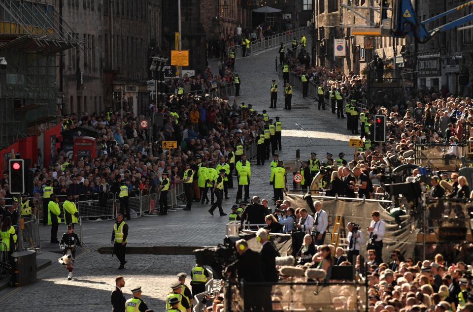 People gather to see the coffin of Queen Elizabeth II leaving St Giles Cathedral, in Edinburgh, Scotland, Tuesday, Sept. 13, 2022. King Charles III and Camilla, the Queen Consort, flew to Belfast from Edinburgh on Tuesday, the same day the queen’s coffin will be flown to London from Scotland. (Louisa Gouliamaki/Pool Photo via AP)