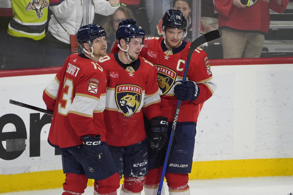 Florida Panthers right wing Vladimir Tarasenko (10) is congratulated by centers Sam Reinhart (13) and Aleksander Barkov (16) after he scored a goal during the third period of an NHL hockey game against the Columbus Blue Jackets, Thursday, April 11, 2024, in Sunrise, Fla. (AP Photo/Marta Lavandier)