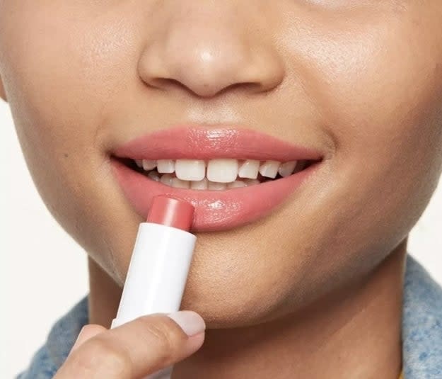 model applying balm to lips