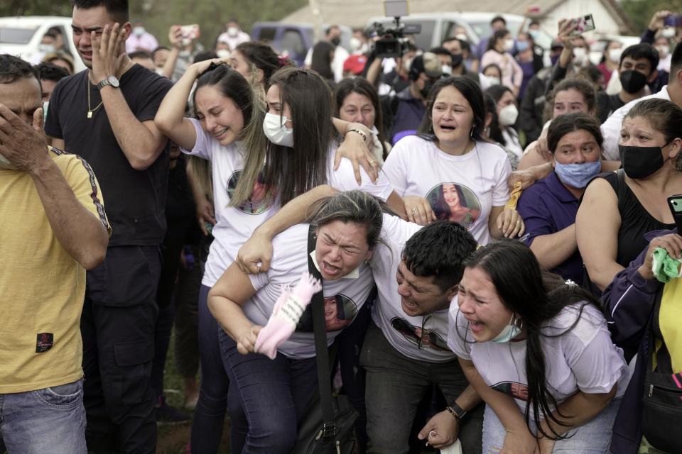 Friends and relatives of Leidy Vanessa Luna Villalba react as the coffin that contain her remains arrives outside her home, in Eugenio Garay, Paraguay, Tuesday, July 13, 2021. Luna Villalba, a nanny employed by the sister of Paraguay's first lady Silvana Lopez Moreira, was among those who died in the Champlain Towers South condominium collapse in Surfside, Florida on June 24. (AP Photo/Jorge Saenz)