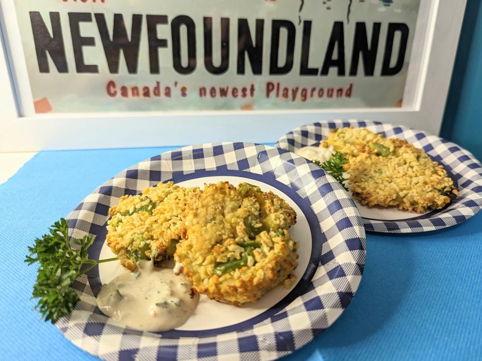 two paper gingham plates with crab cakes on them in front of a newfoundland sign