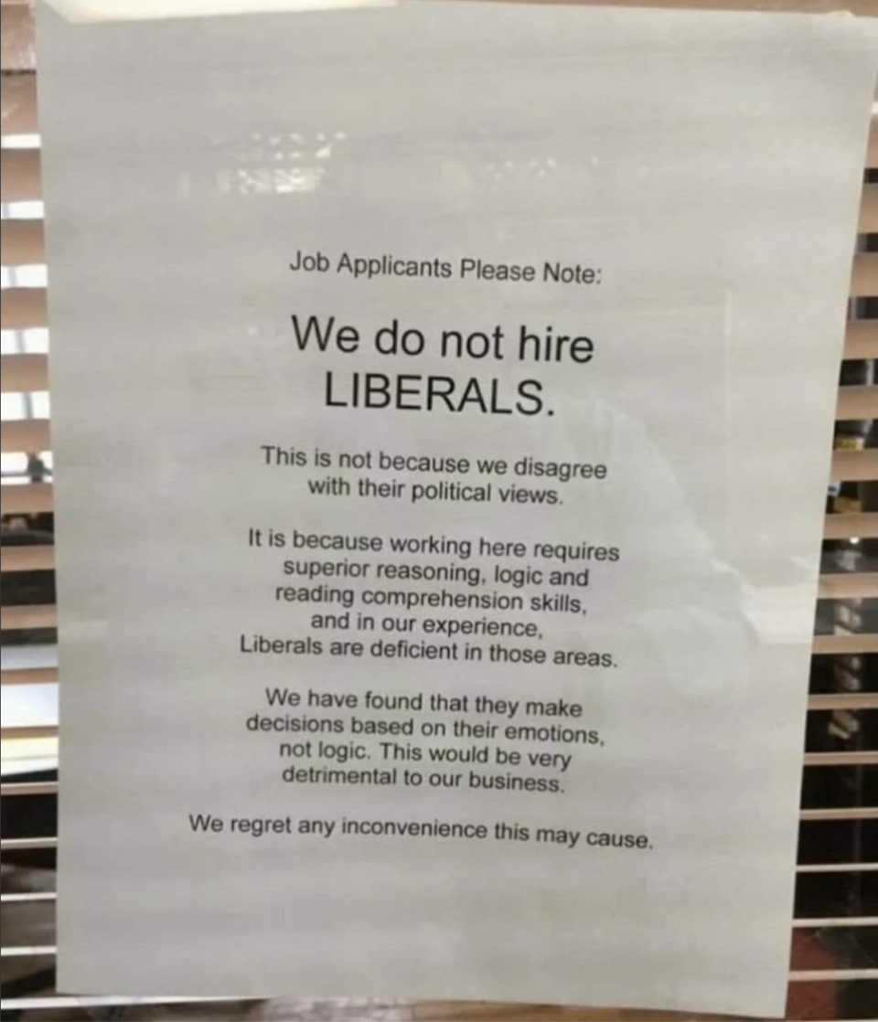 A printed sign states that the company does not hire liberals, citing reasons such as perceived deficiencies in reasoning, logic, and reading comprehension skills