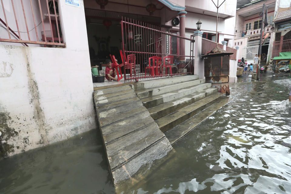 A woman cleans her flood-damaged house in Jakarta, Indonesia, Sunday, Jan. 5, 2020. Landslides and floods triggered by torrential downpours have left dozens of people dead in and around Indonesia's capital, as rescuers struggled to search for people apparently buried under tons of mud, officials said Saturday. (AP Photo/Tatan Syuflana)