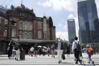 People walk across a crossing near Tokyo Station in Tokyo Thursday, July 29, 2021, a day after the record-high coronavirus cases were found in the Olympics host city. (AP Photo/Kantaro Komiya)