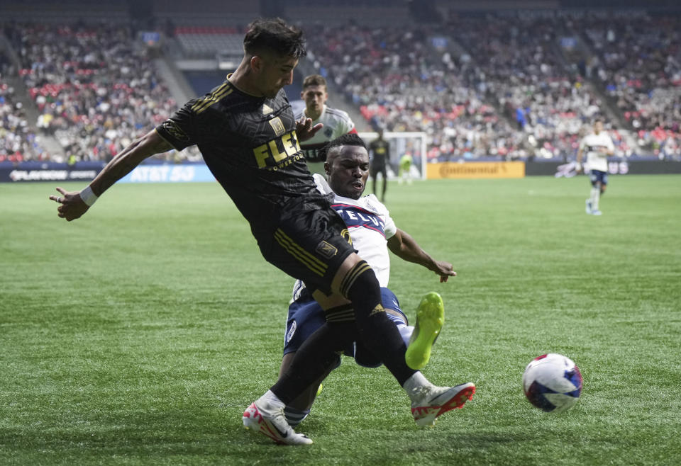 Los Angeles FC's Cristian Olivera, left, and Vancouver Whitecaps' Sam Adekugbe, right, vie for the ball during the second half in Game 2 of a first-round MLS playoff soccer match in Vancouver, British Columbia, Sunday, Nov. 5, 2023. (Darryl Dyck/The Canadian Press via AP)