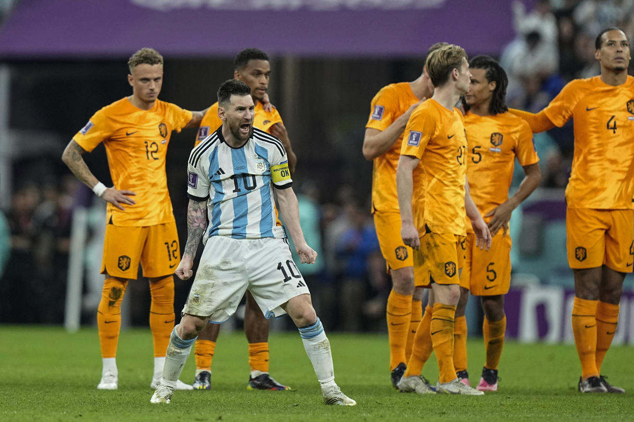 Argentina's Lionel Messi celebrates in front of Netherlands players at the end of the World Cup quarterfinal match at the Lusail Stadium in Lusail, Qatar, Saturday, Dec. 10, 2022. (AP Photo/Jorge Saenz)