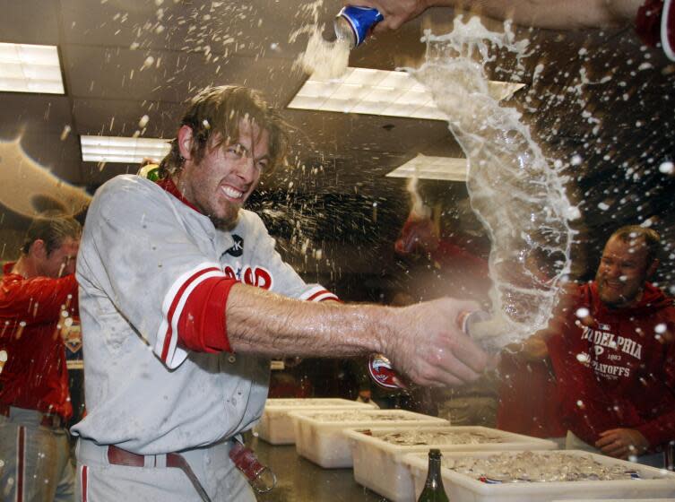 Philadelphia Phillies' Jayson Werth sprays teammates in the clubhouse as they celebrate their 5-4 win over the Colorado Rockies in Game 4 in a National League baseball division series in Denver on Monday, Oct. 12, 2009. The Philadelphia Phillies will face the Los Angeles Dodgers in the NL Championship Series. (AP Photo/Jack Dempsey)
