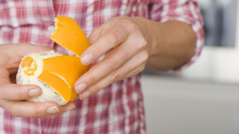 hands peeling an orange