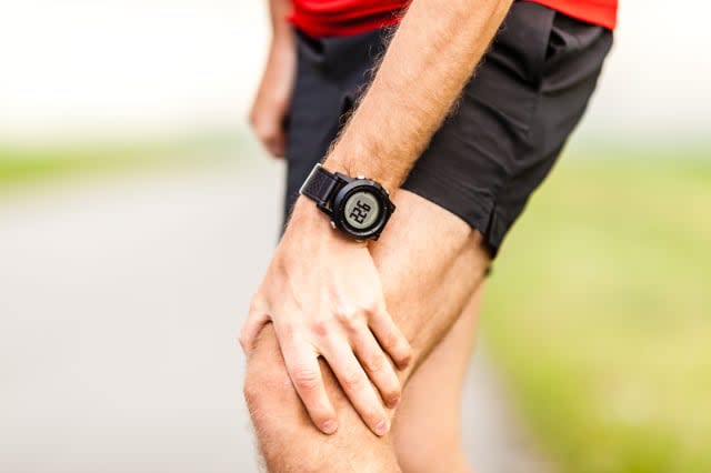 runner holding sore leg  knee...