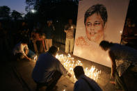 FILE- In this Jan. 15, 2009 file photo, activists and members of Sri Lankan civil societies light candles in front of a portrait of Sunday Leader newspaper editor Lasanthe Wickrematunge in a silent vigil condemning his killing, in Colombo, Sri Lanka. Forced to flee their country a decade ago to escape allegedly state-sponsored killer squads, Sri Lankan journalists living in exile doubt they’ll be able to return home soon or see justice served to their tormentors _ whose alleged ringleader could come to power in this weekend’s presidential election. Exiled journalists and media rights groups are expressing disappointment over the current government’s failure in punishing the culprits responsible for crimes committed against media members. (AP Photo/Gemunu Amarasinghe, File)