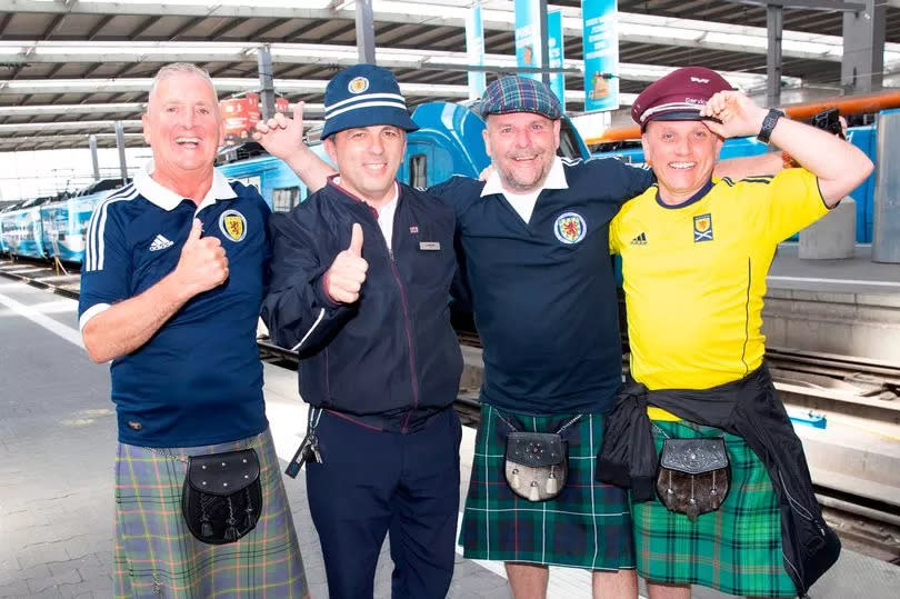 Derek Corbett, Gavin Bass and Martin Ross from Tain swap hats with train conductor Goran Nasteshi from Macedonia