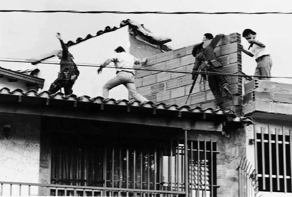 Die kolumbianische Polizei und Streitkräfte stürmen das Dach, auf dem Drogenbaron Pablo Escobar im Dezember 1993 erschossen wurde. (AFP über Getty Images)