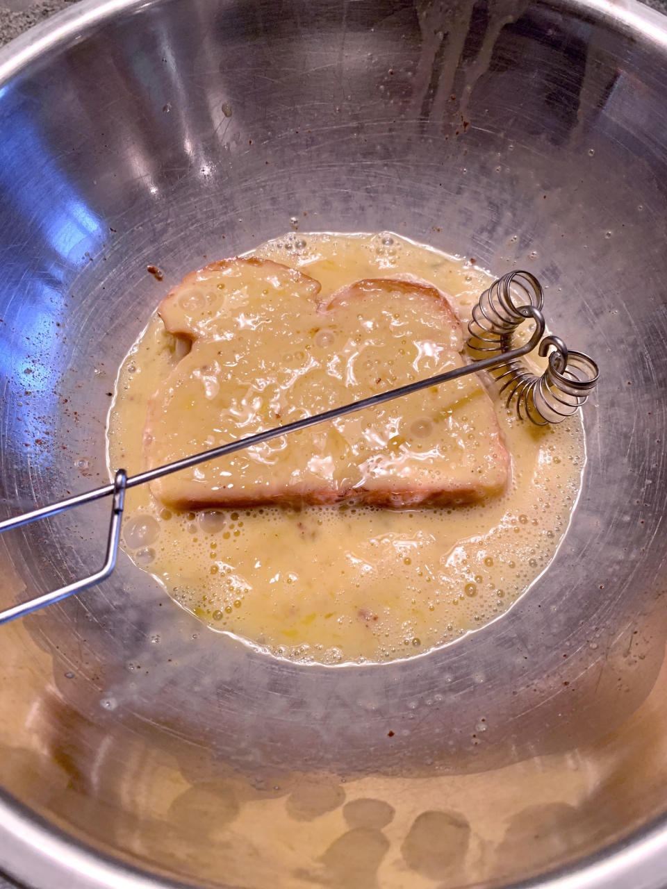 Dipping bread in an egg mixture.