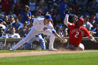 Cincinnati Reds' Nick Castellanos (2) scores past Chicago Cubs relief pitcher Codi Heuer, left, on a wild pitch during the sixth inning of a baseball game, Monday, Sept. 6, 2021, in Chicago. (AP Photo/Matt Marton)