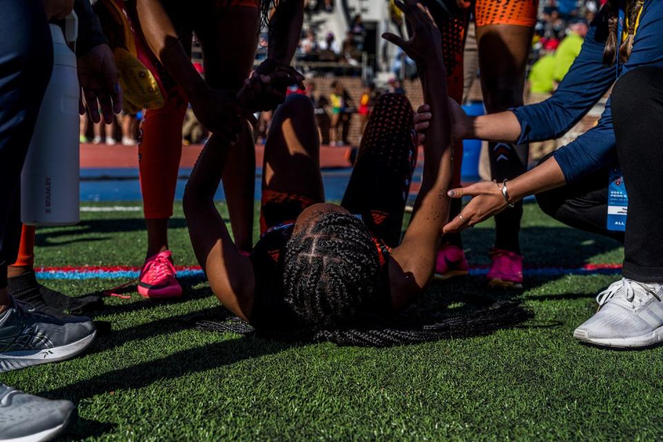 people help out an athlete on the ground