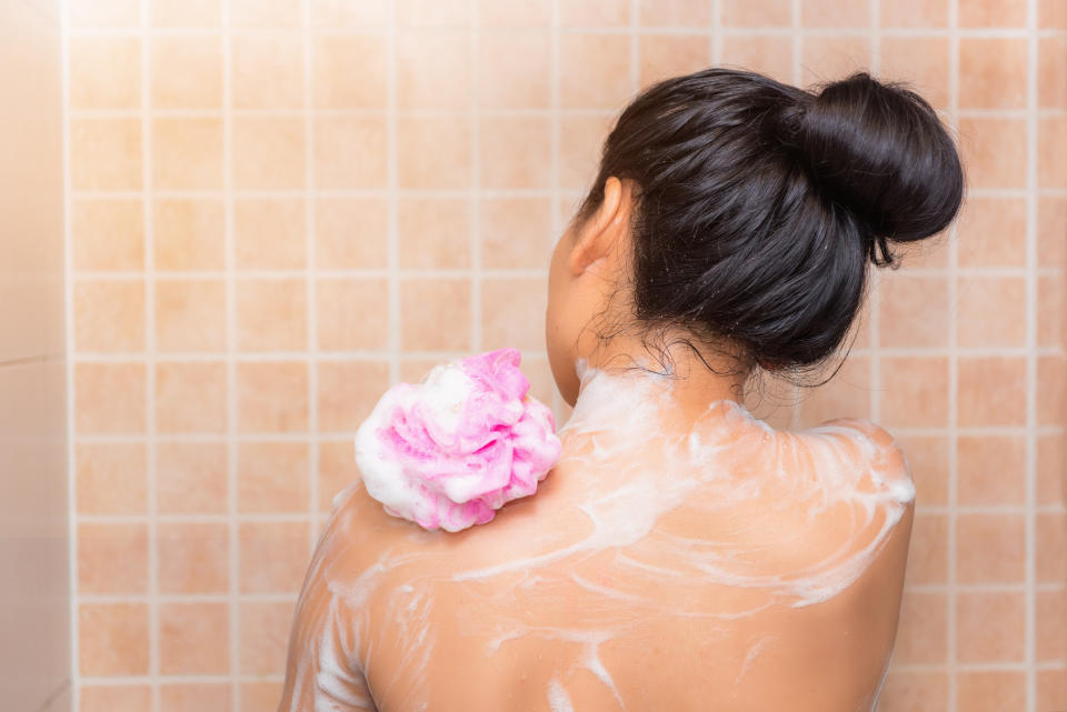 Portrait of beautiful woman taking shower with bath sponge., Health skincare concept.