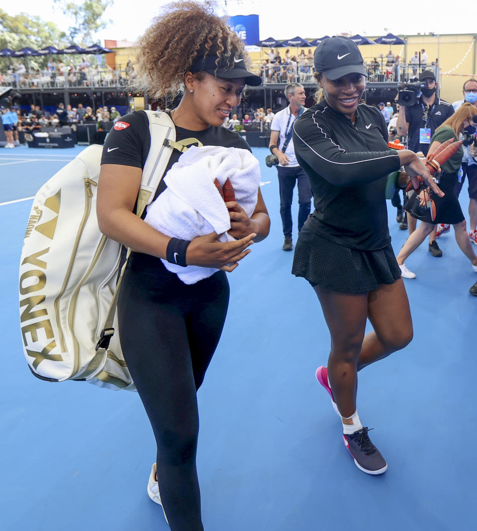 Naomi Osaka, left, of Japan and Serena Williams of the U.S. walk from the court together following an exhibition tennis event in Adelaide, Australia, Friday, Jan 29. 2021. (Kelly Barnes/AAP Image via AP)