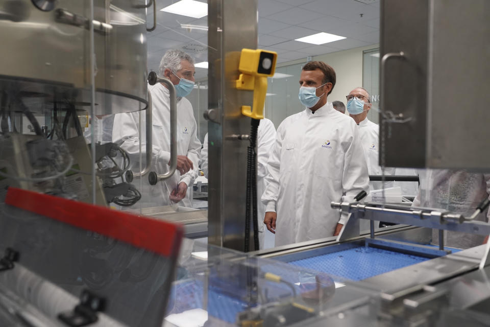 French President Emmanuel Macron listens to a researcher as he visits an industrial development laboratory at French drugmaker's vaccine unit Sanofi Pasteur plant in Marcy-l'Etoile, near Lyon, central France, Tuesday, June 16, 2020.The visit comes after rival pharmaceutical company AstraZeneca this weekend announced a deal to supply 400 million vaccine doses to EU countries, including France. (AP Photo/Laurent Cipriani, Pool)