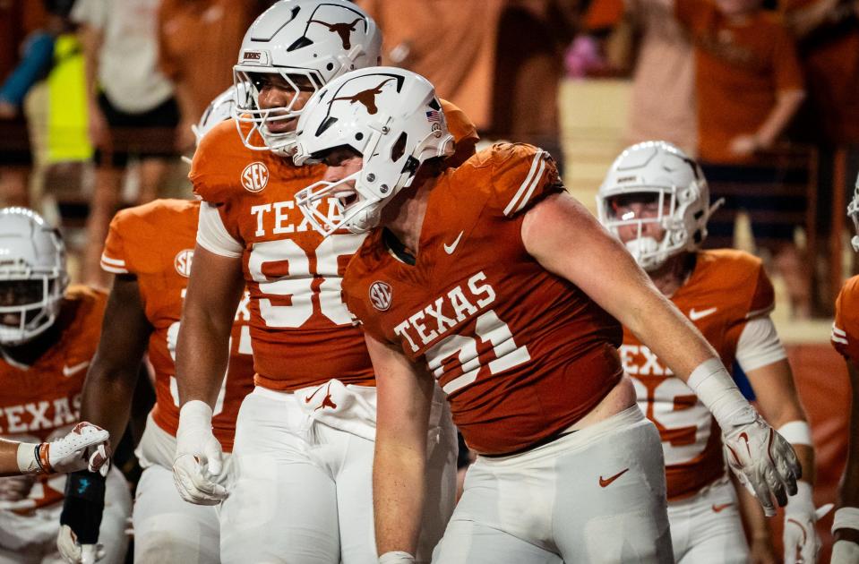 Texas defensive end Ethan Burke celebrates with teammates after scoring on a 30-yard interception return in Saturday's 56-7 win over UTSA. The Horns have six takeaways through three games this season.