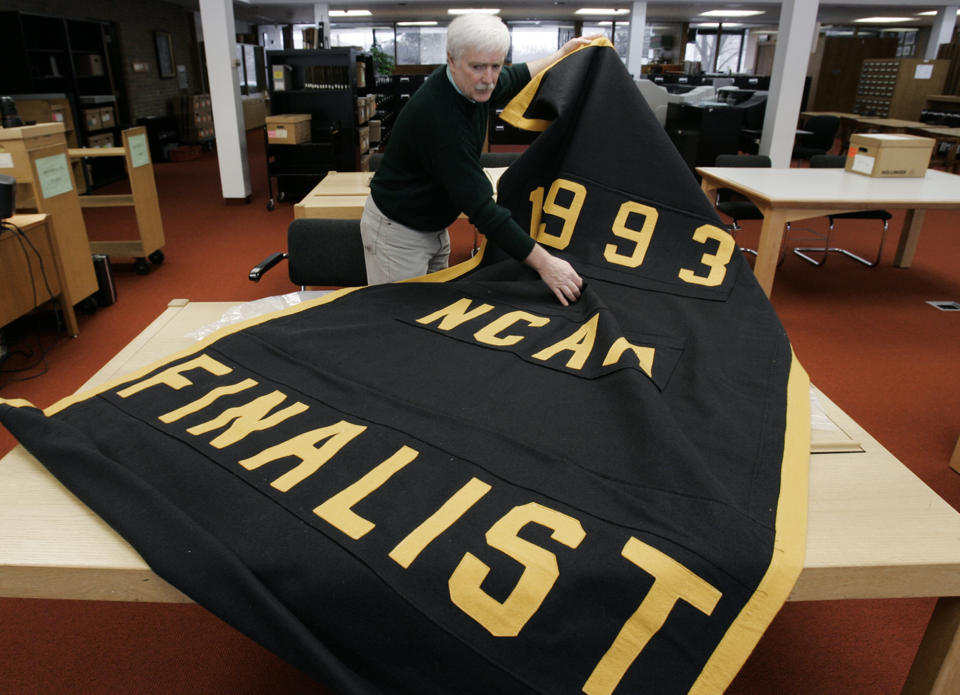 FILE - Greg Kinney, archivist at the University of Michigan Bentley Historical Library, unrolls the 1993 NCAA college basketball tournament finalist banner being kept in storage in Ann Arbor, Mich., Feb. 6, 2007. An NCAA scandal led to the removal of two Final Four banners, including the 1993 item, from the Crisler Center rafters. (AP Photo/Paul Sancya, File)