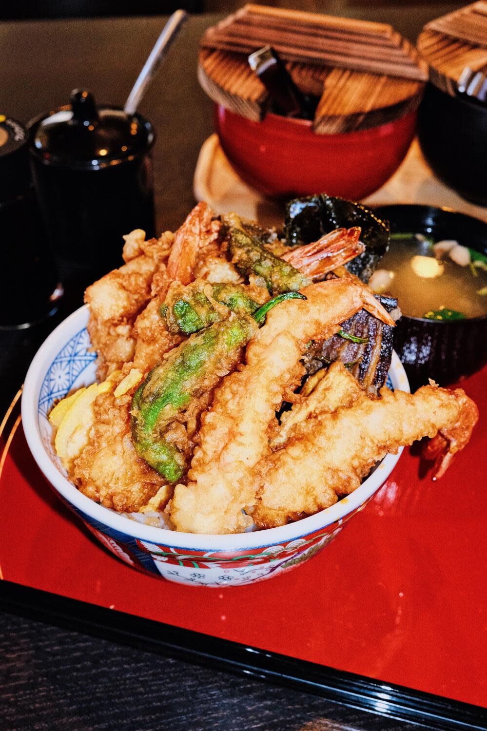 A side view of a rice bowl brimming with fried shrimp and vegetables on a red tray at Tendon Tempura Carlos Jr. in Pasadena