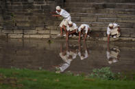 Men perform rituals on the banks of the Bagmati River in Kathmandu, Nepal, Tuesday, May 24, 2022. Hindus flock to the Bagmati to worship at shrines and celebrate festivals. Women dip in the river to wash away sins during Rishipanchami, a day for worship of the seven sages revered as enlightened beings guiding humanity through the ages. Visitors also wade in during the festival of Chhath, praying to the sun god Surya. During Teej, married women come to pray for the health and prosperity of their husbands, and single women, to find a good one. (AP Photo/Niranjan Shrestha)