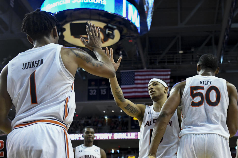 Auburn guard Samir Doughty (10) celebrates a score and foul called against Georgia with teammates during the second half of an NCAA college basketball game Saturday, Jan. 11 2020, in Auburn, Ala. (AP Photo/Julie Bennett)