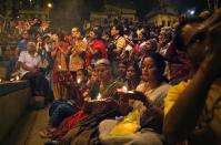 In this Monday, March 31, 2014, photo, Indian devotees and tourists participate in a pray ceremony on the banks of the river Ganges, in Varanasi, India. For tens of millions of people, the city of Varanasi, on the banks of the river Ganges, is a place of pilgrimage, where devout Hindus believe they earn instant salvation. But in recent weeks Varanasi also has become the noisy battleground for India's most-watched contest in its national elections: Two of the country’s most prominent politicians are facing off in a contest for the city’s sole parliamentary seat. (AP Photo /Manish Swarup)