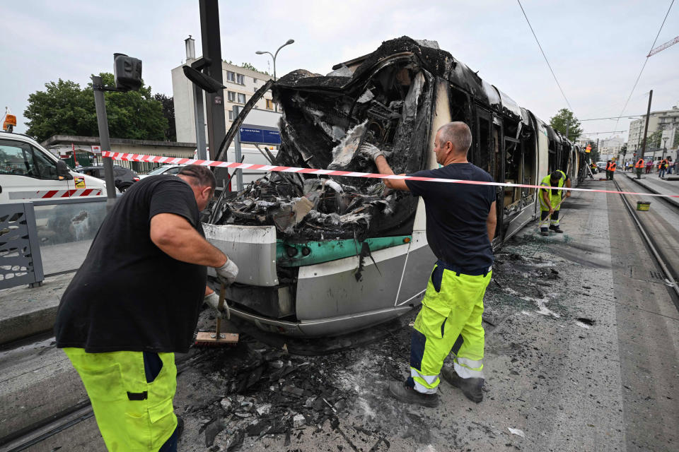 Workers clean up the debris of a burnt tram destroyed during protests the previous night in Clamart, southwest of Paris, on June 29, 2023.<span class="copyright">Emmanuel Dunand—AFP/Getty Images</span>