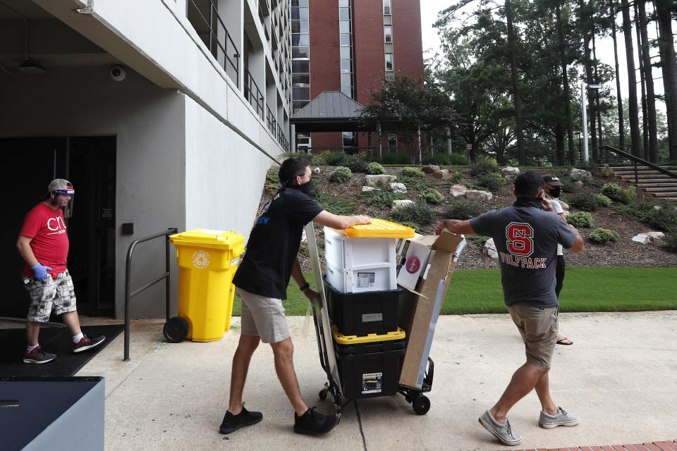 FILE - In this July 31, 2020, file photo, college students begin moving in for the fall semester at N.C. State University in Raleigh, N.C. As they struggle to salvage some semblance of a campus experience this fall, U.S. colleges are requiring promises from students to help contain the coronavirus — no keg parties, no long road trips and no outside guests on campus. (AP Photo/Gerry Broome, File)