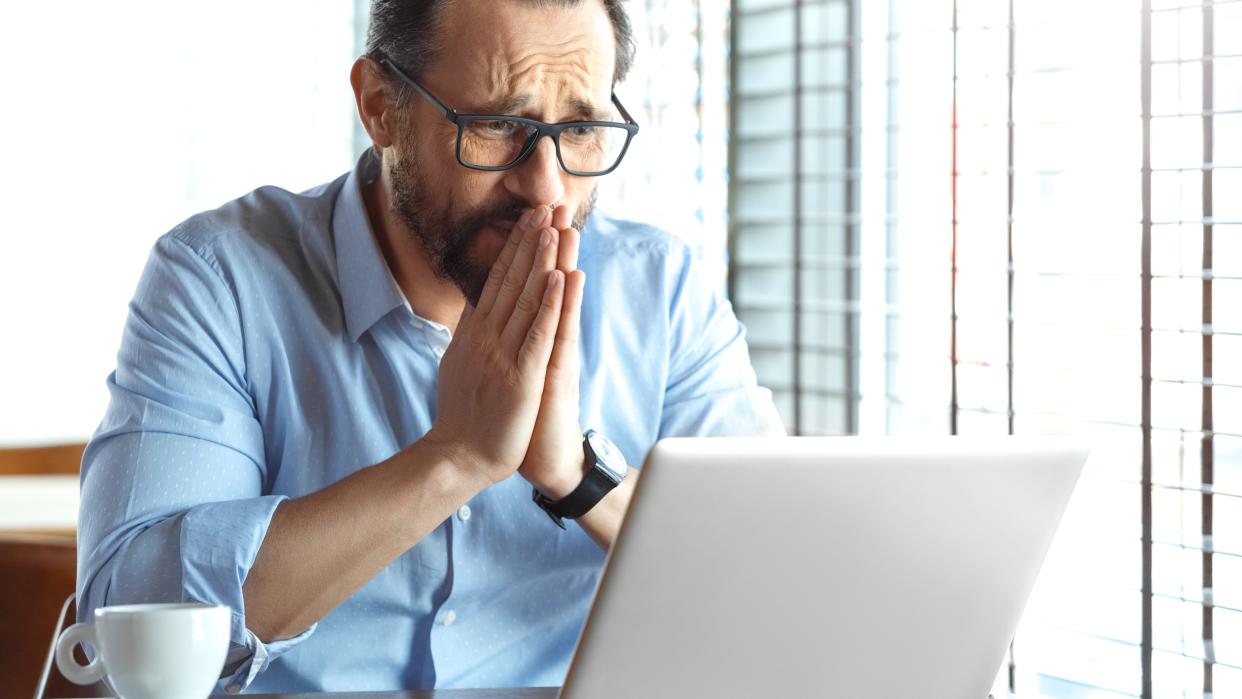  Man looking in hope at a laptop 