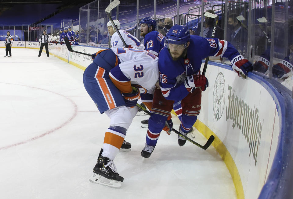 New York Rangers' Ryan Lindgren, right, holds on to New York Islanders' Ross Johnston (32 during the third period of an NHL hockey game Saturday, Jan. 16, 2021, in New York. (Bruce Bennett/Pool Photo via AP)