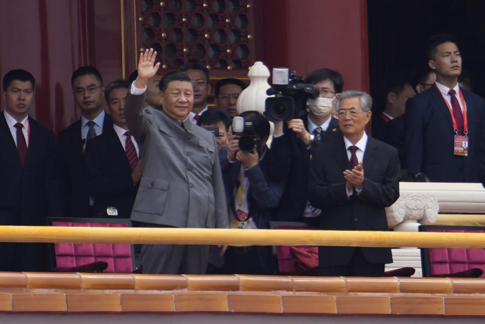 Chinese President Xi Jinping, center, waves next to former President Hu Jintao, right, during a ceremony to mark the 100th anniversary of the founding of the ruling Chinese Communist Party at Tiananmen Gate in Beijing Thursday, July 1, 2021. (AP Photo/Ng Han Guan)