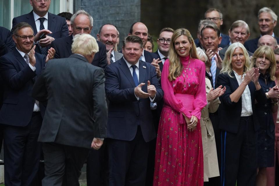 Outgoing Prime Minister Boris Johnson walks toward his wife Carrie Johnson and well-wishers as they leave Downing Street, London. (PA)