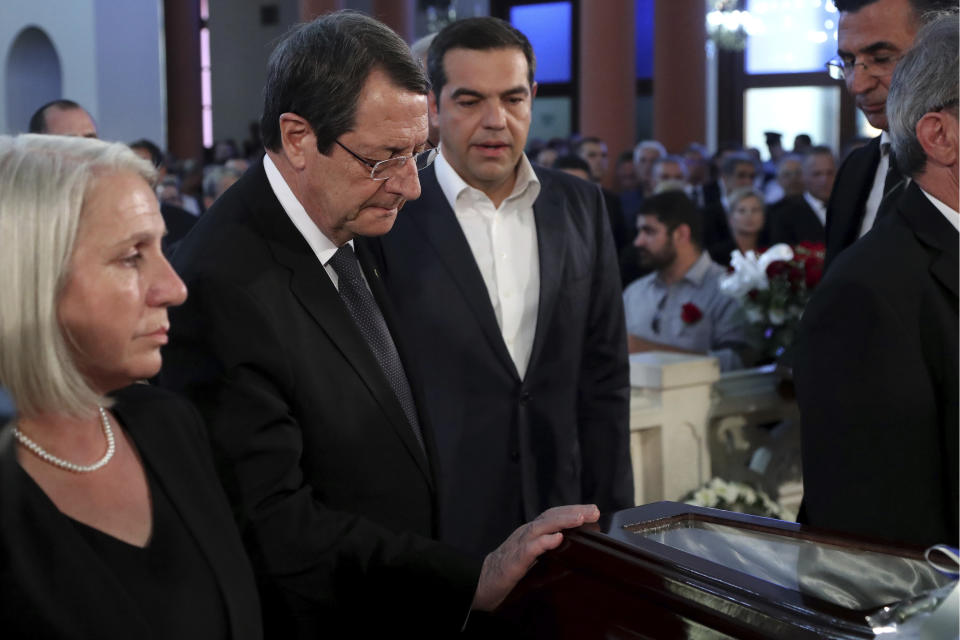 Cyprus' president Nicos Anastasiades, center, touches the coffin of the former Cyprus' President Dimitris Christofias as Greece's Prime minister Alexis Tsipras looks on, during Christofias' state funeral at the Orthodox Christian Church of the Lord's Wisdom in capital Nicosia, Cyprus, Tuesday, June 25, 2019. European communist and left-wing party heads and leaders from ethnically split Cyprus' breakaway Turkish Cypriot community were among those attending a funeral service for the country's former president Christofias. (AP Photo/Petros Karadjias)