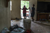 Gavin Holmes, 9, left, and his brother, Tyce, 7, stand in their damaged home as the family packs up while forced to leave after severe flooding in Fromberg, Mont., Friday, June 17, 2022. (AP Photo/David Goldman)