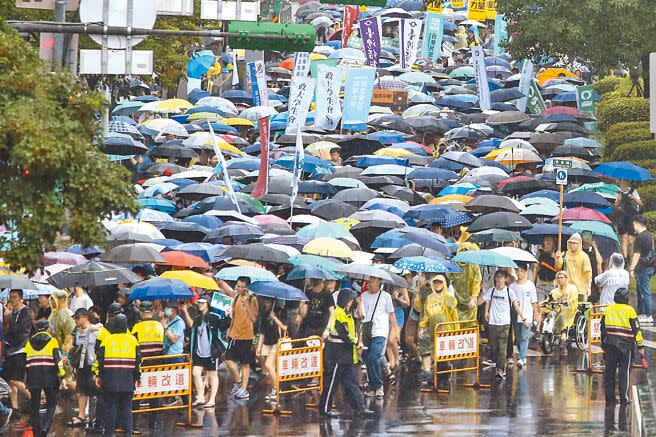 由行人零死亡推動聯盟發起的還路於民大遊行20日在台北凱達格蘭大道舉行，活動開始現場就下起大雨，仍有許多民眾撐傘、穿雨衣到場相挺。（鄧博仁攝）