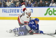 Ottawa Senators forward Josh Norris (9) trips Toronto Maple Leafs forward Mitchell Marner (16) during third-period NHL hockey game action in Toronto, Saturday, Oct. 16, 2021. (Evan Buhler/The Canadian Press via AP)